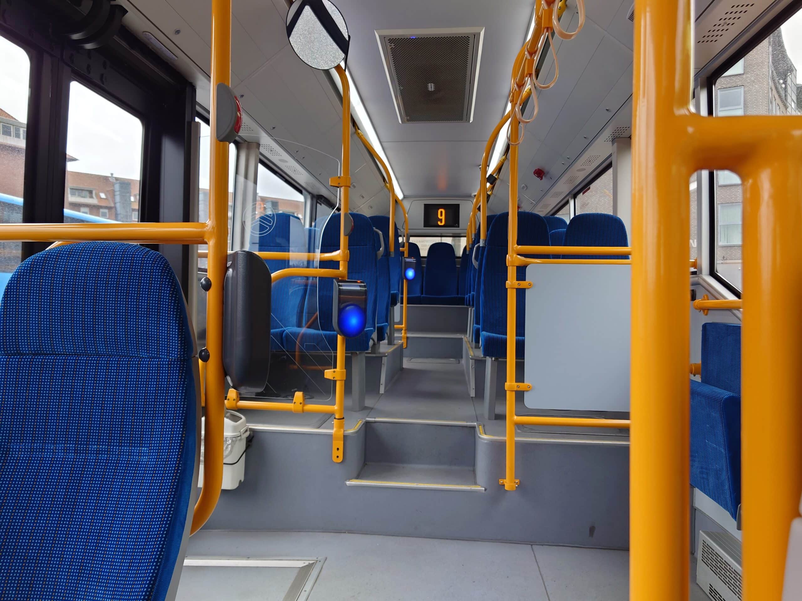 bus interiør med blå sæder og gule stænger